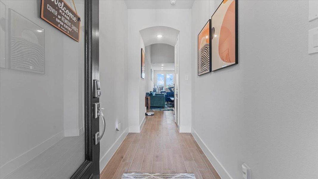 Hallway featuring arched walkways, wood finish floors, and recessed lighting Hallway featuring arched walkways, wood finish floors, and recessed lighting