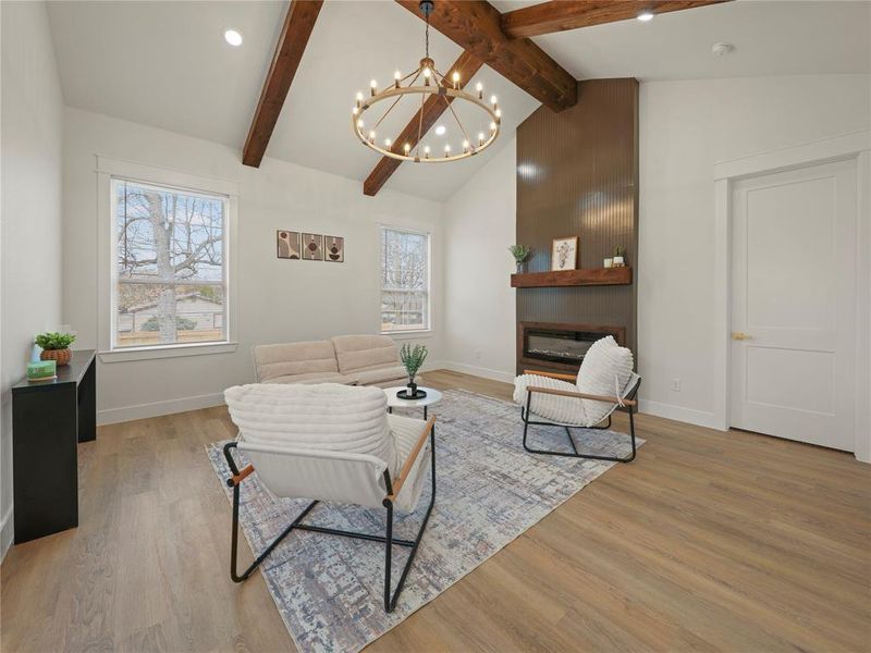 Living room featuring a fireplace, suspended lighting, and light wood-type flooring