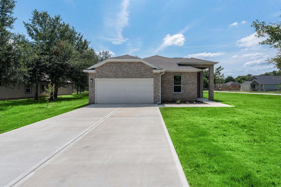 This photo shows a modern brick house with a spacious driveway leading to a two-car garage. The home is surrounded by a well-maintained lawn and mature trees, providing a serene and private setting under a clear blue sky. This photo shows a modern brick house with a spacious driveway leading to a two-car garage. The home is surrounded by a well-maintained lawn and mature trees, providing a serene and private setting under a clear blue sky.