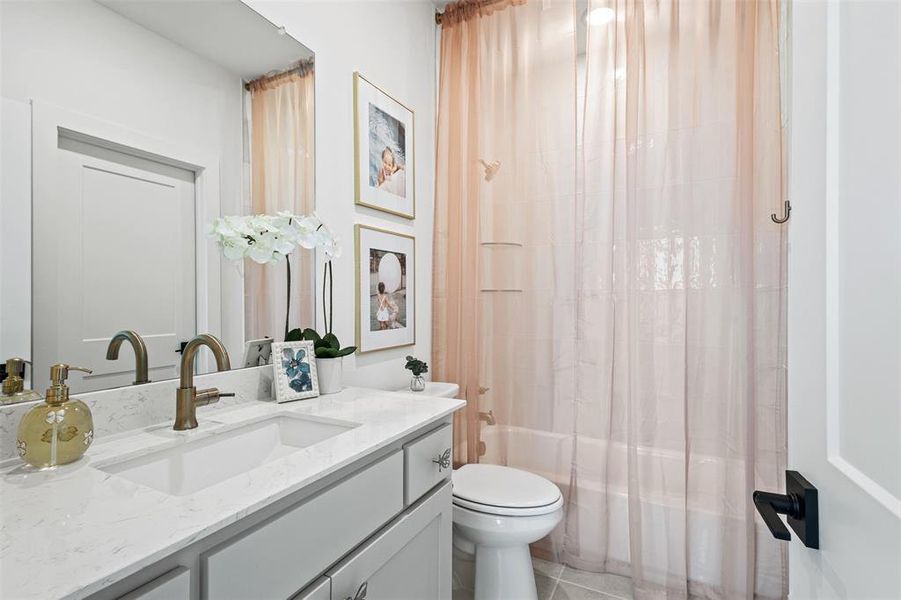 Full bathroom featuring shower / bath combo with shower curtain, vanity, and light tile patterned flooring Full bathroom featuring shower / bath combo with shower curtain, vanity, and light tile patterned flooring