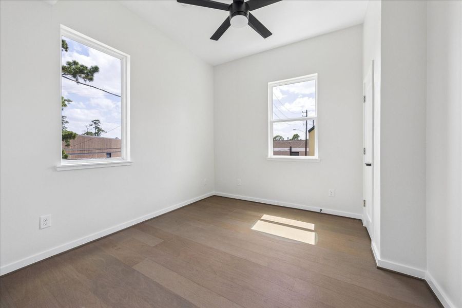 Bright secondary bedroom featuring large windows, soaring ceilings, and abundant natural light. Bright secondary bedroom featuring large windows, soaring ceilings, and abundant natural light.