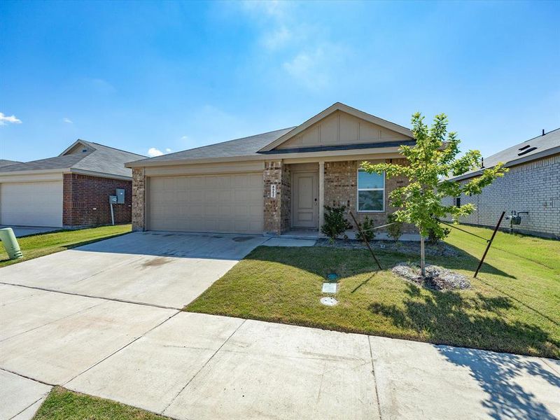Brick and siding exterior featuring a covered entry, attached garage, and a concrete driveway