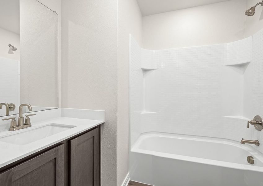 The secondary bathroom has a large vanity space and a shower-tub combo. The secondary bathroom has a large vanity space and a shower-tub combo.