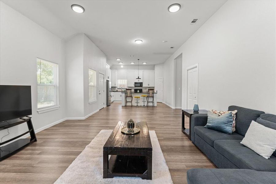 Living area featuring dark wood finished floors and recessed lighting