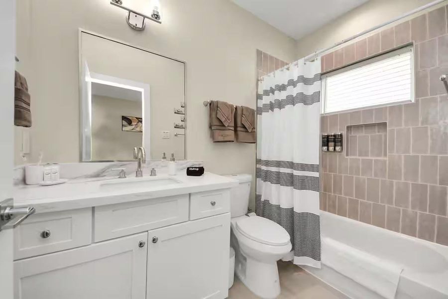 A full secondary bath with vanity storage and a tiled tub/shower combination keeps the upstairs layout practical for guests or additional occupants.
