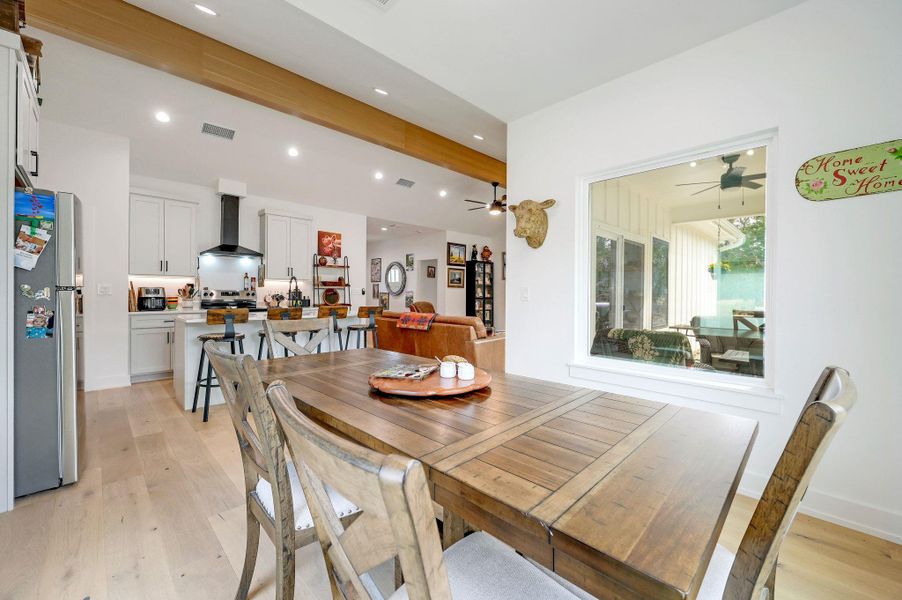 Dining room featuring beamed ceiling, light wood-style flooring, recessed lighting, and ceiling fan