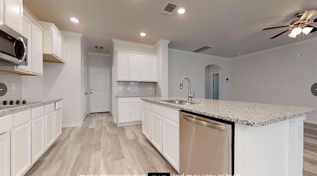Kitchen featuring appliances with stainless steel finishes, a sink, arched walkways, a ceiling fan, and light wood-style floors