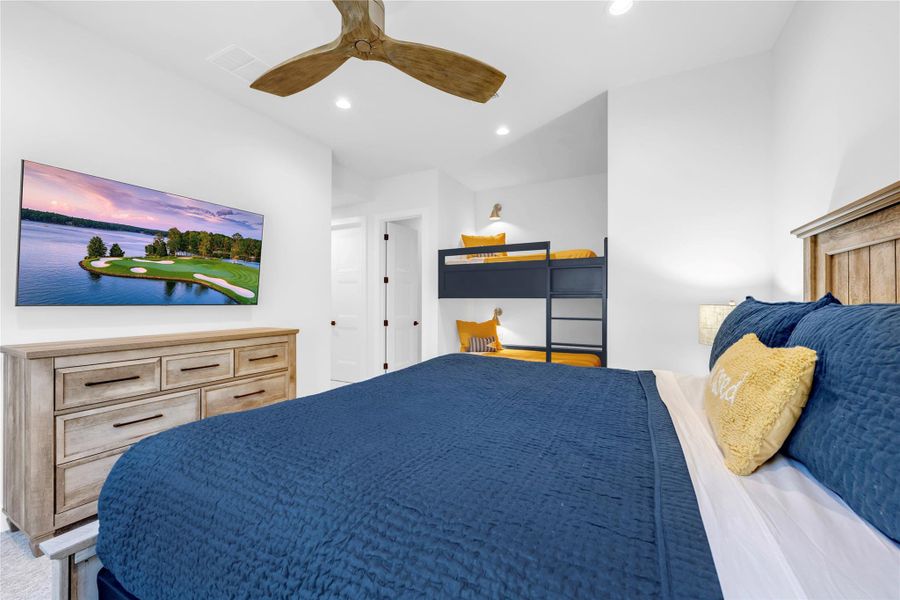 Bedroom six: Crisp recessed lighting illuminates this guest bedroom featuring soft carpet and integrated bunk beds.