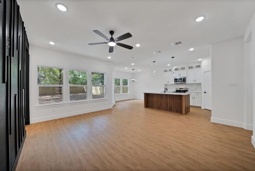 Unfurnished living room with light wood-type flooring, recessed lighting, and a ceiling fan