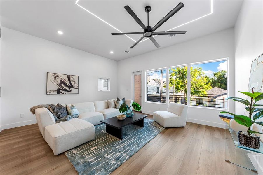 Living room featuring wood finished floors, a ceiling fan, and recessed lighting Living room featuring wood finished floors, a ceiling fan, and recessed lighting