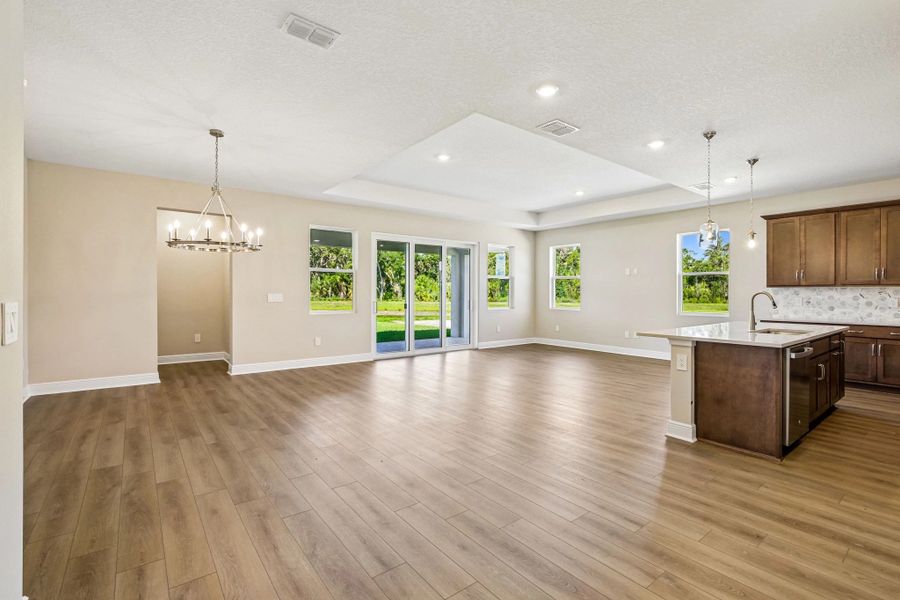 As you continue down the foyer you enter into the open family room, dining room and kitchen space