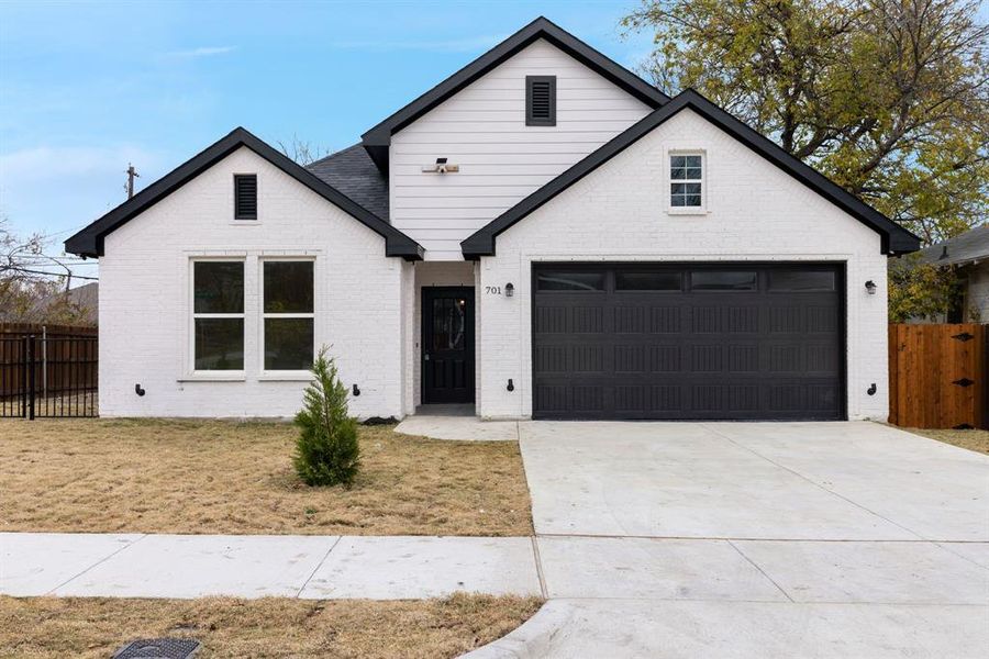 Modern farmhouse featuring a garage and a front yard