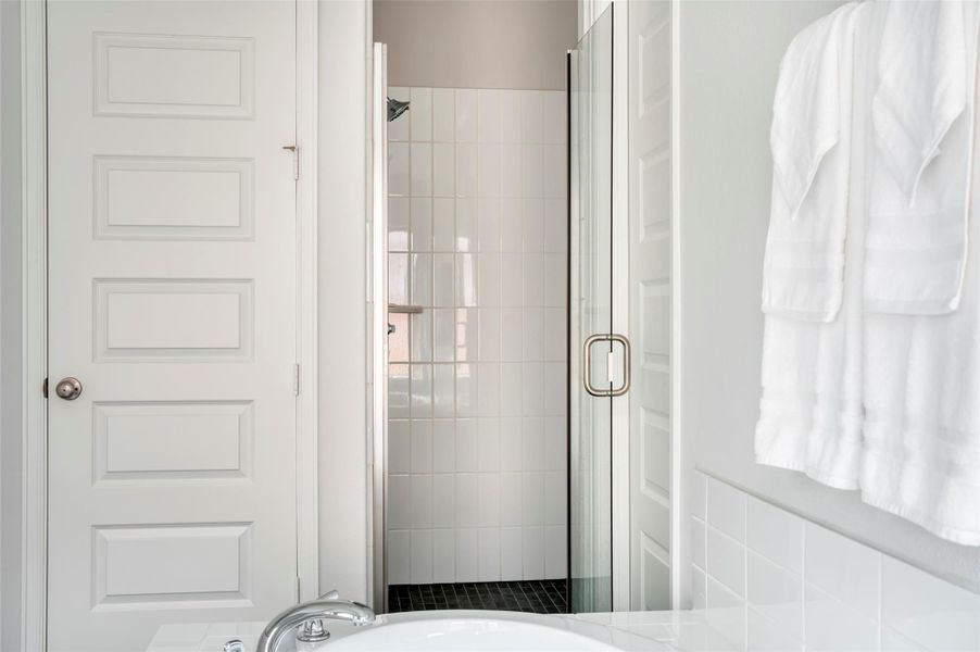 This bathroom features a modern design with a glass-enclosed shower, white tiled walls, and neatly hung towels, offering a clean and inviting space. This bathroom features a modern design with a glass-enclosed shower, white tiled walls, and neatly hung towels, offering a clean and inviting space.