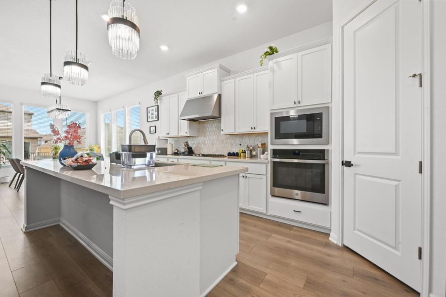 Gleaming stone countertops and crisp white cabinetry ground this modern culinary space.