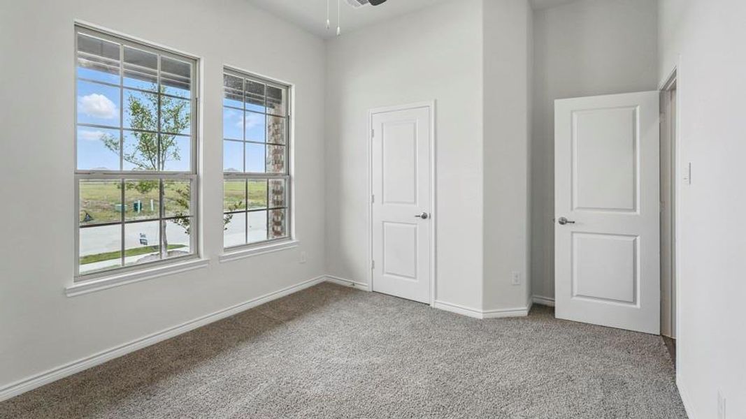 Room featuring two large windows with grid muntins, light gray carpeting, and white baseboards