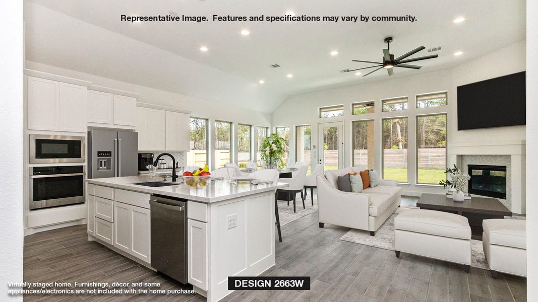 Kitchen with stainless steel appliances, a sink, white cabinetry, open floor plan, and a glass covered fireplace