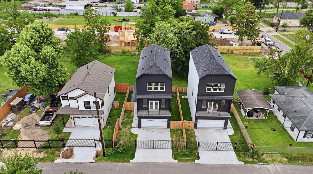 New construction perfection, seen from above. This striking aerial view of the two-tone modern exterior, private driveway and iron fencing, shows exactly why this home stands out in one of Houston's fastest-growing corridors. New construction perfection, seen from above. This striking aerial view of the two-tone modern exterior, private driveway and iron fencing, shows exactly why this home stands out in one of Houston's fastest-growing corridors.