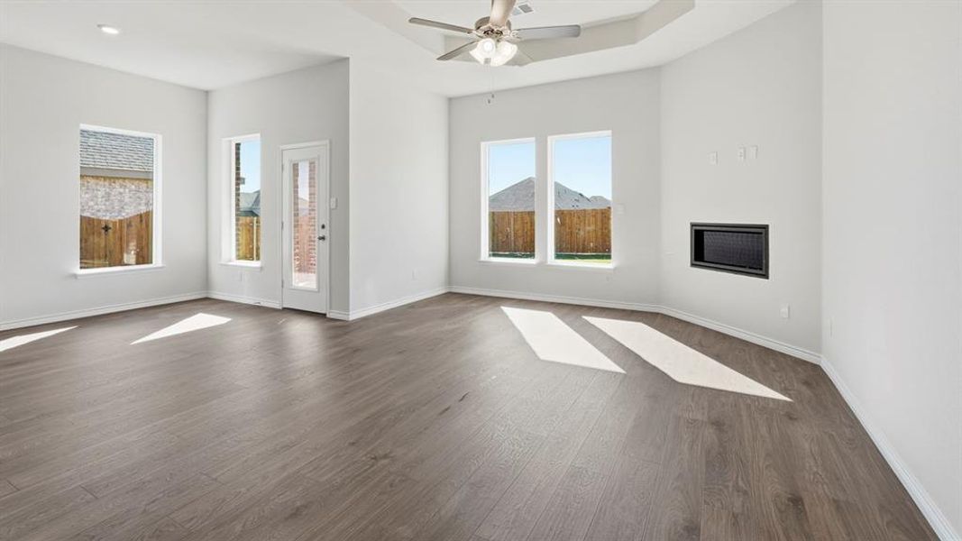 Unfurnished living room featuring dark wood finished floors and ceiling fan Unfurnished living room featuring dark wood finished floors and ceiling fan