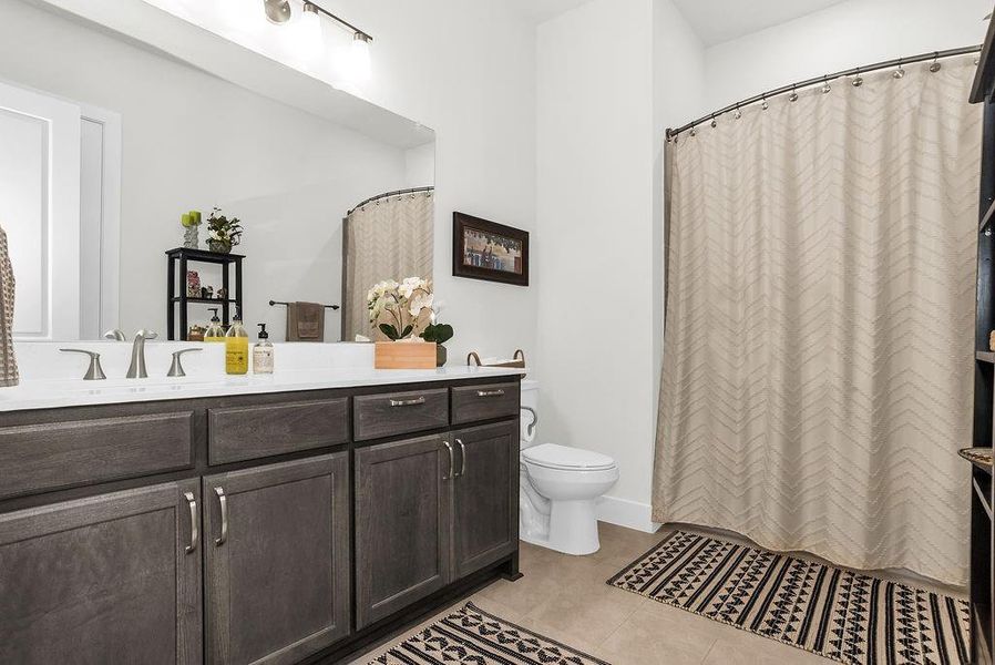 Bathroom featuring dark wood-finish cabinetry, pendent lighting, and brushed nickel fixtures