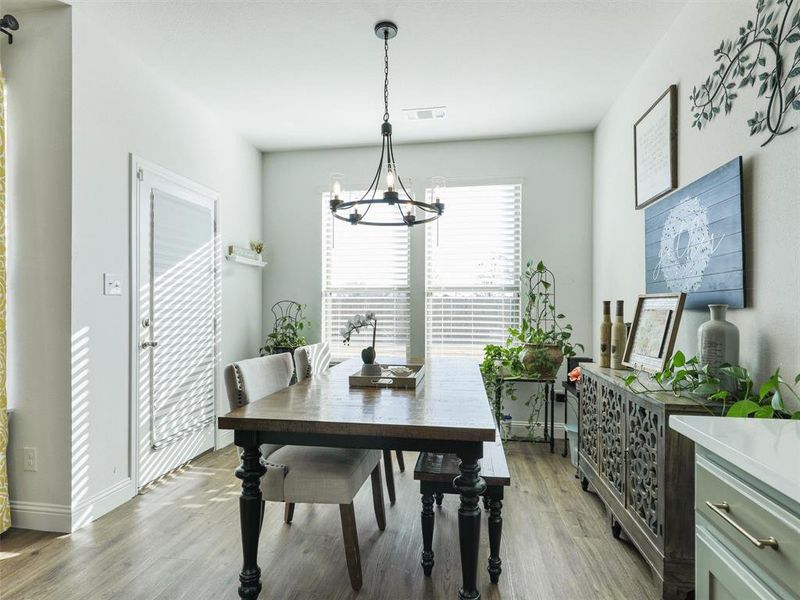 Dining area featuring light wood-type flooring and a chandelier