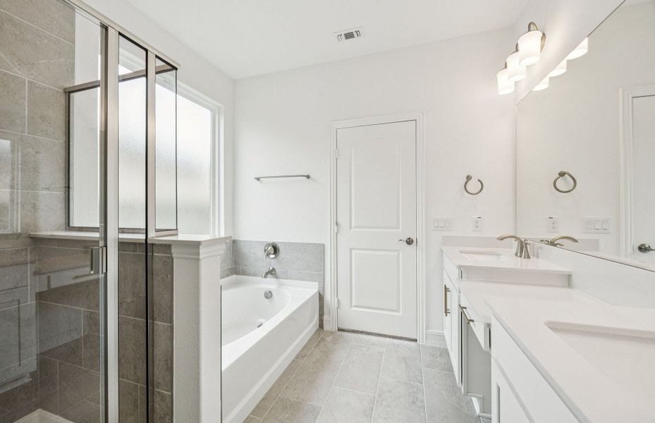 Modern owner's bath with dual vanities and a spacious shower  *Real home pictured