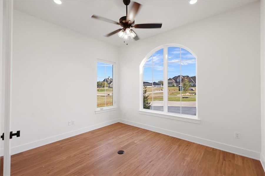 Spare room featuring wood finished floors, a ceiling fan, recessed lighting, and a residential view