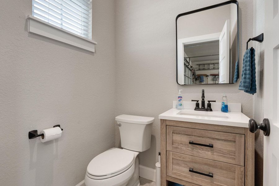 Half bath featuring vanity and a textured wall