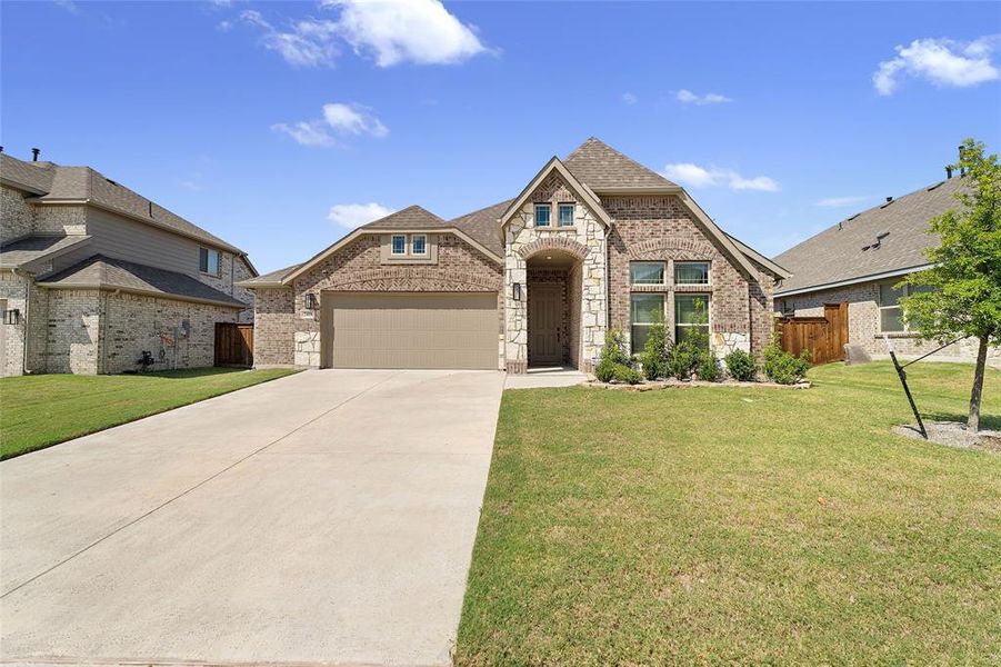 French country home featuring brick siding, driveway, a garage, and a shingled roof French country home featuring brick siding, driveway, a garage, and a shingled roof