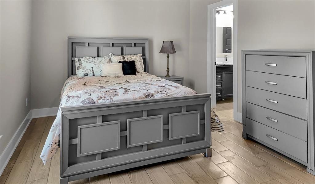 Bedroom with light wood-style floors and ensuite bath