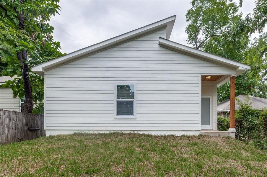 View of property exterior with a yard