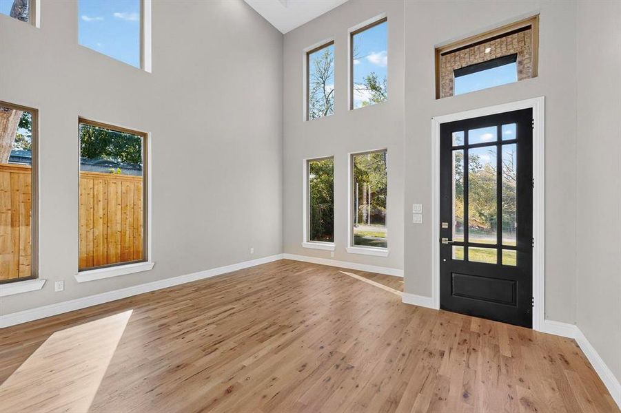 Entryway with a high ceiling and light wood-type flooring