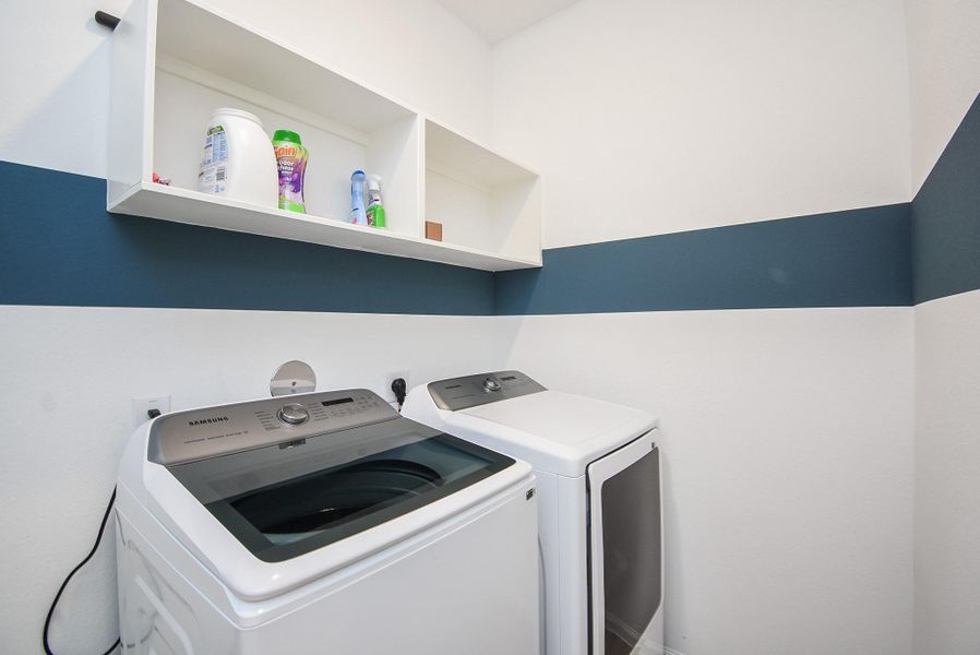 A functional laundry room with built-in shelving and modern appliances.
