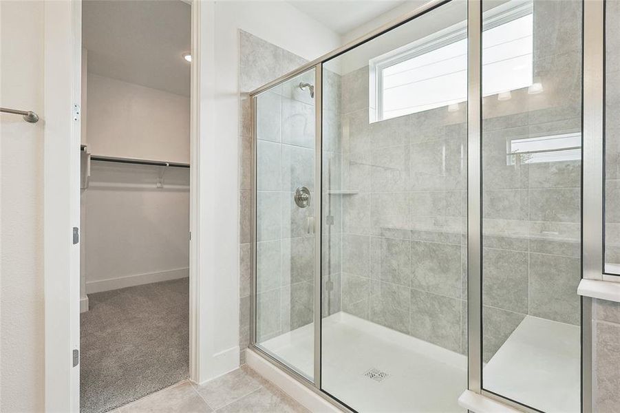 Bathroom featuring tile patterned floors and a shower with door