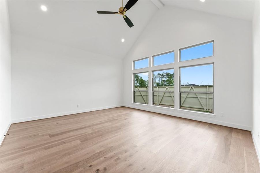 Primary Bedroom with Vaulted Ceiling, Engineered Hardwood Flooring, and Fan.