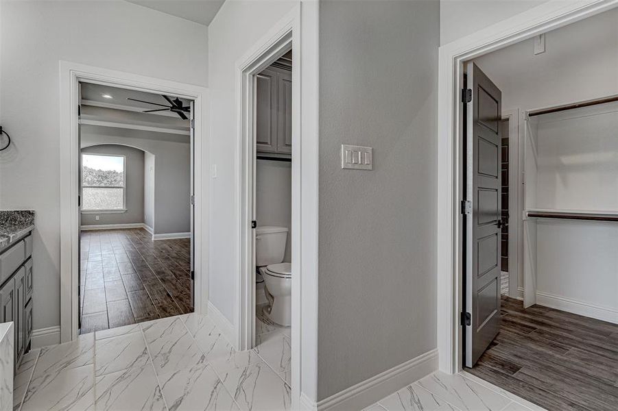 Bathroom with toilet, vanity, and ceiling fan