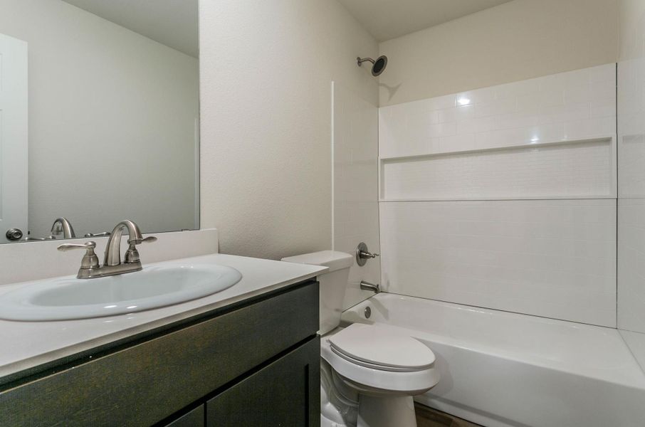 Full bathroom with toilet, vanity, and  shower combination