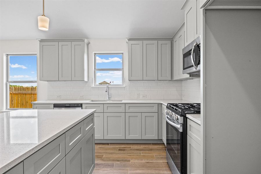 Gleaming stone countertops and classic shaker cabinetry define this modern culinary workspace. Gleaming stone countertops and classic shaker cabinetry define this modern culinary workspace.