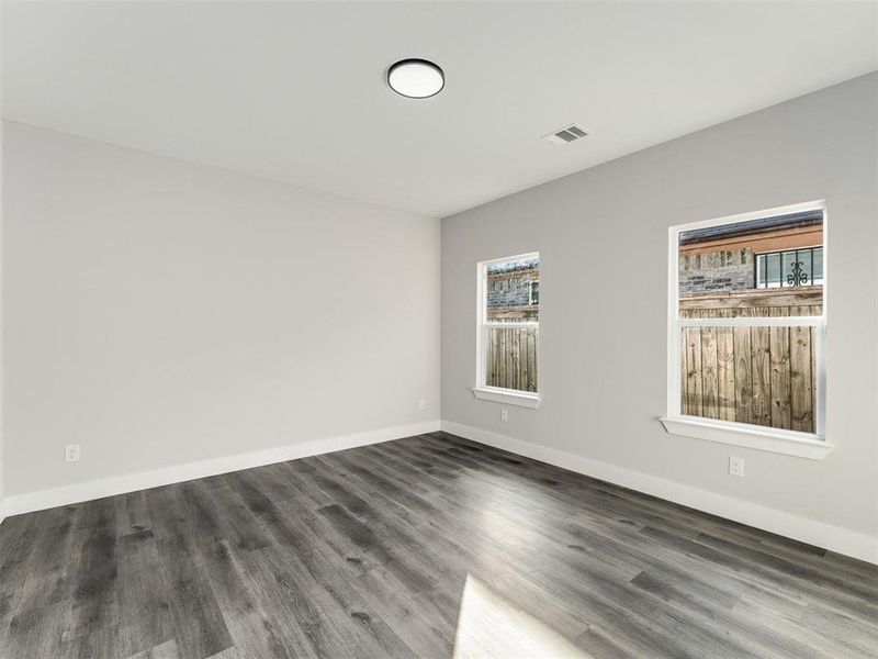 Empty room featuring wood finished floors and baseboards Empty room featuring wood finished floors and baseboards