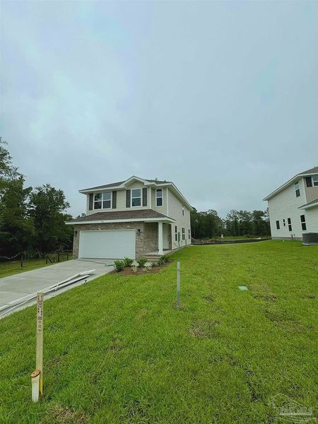 Front exterior of a new home in Pine Top, Cantonment, FL, highlighting curb appeal (Image 2).