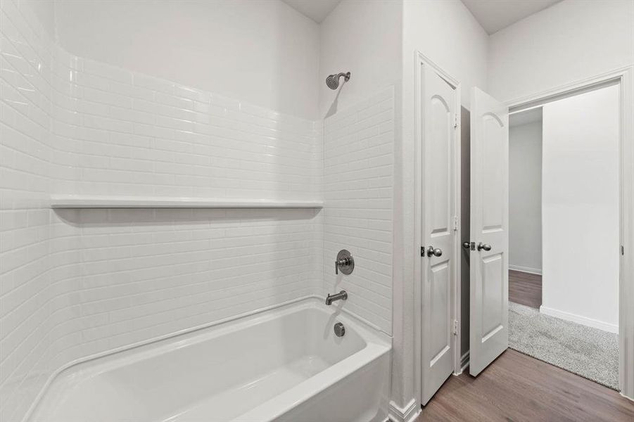 Bathroom with wood finished floors and tub / shower combination Bathroom with wood finished floors and tub / shower combination