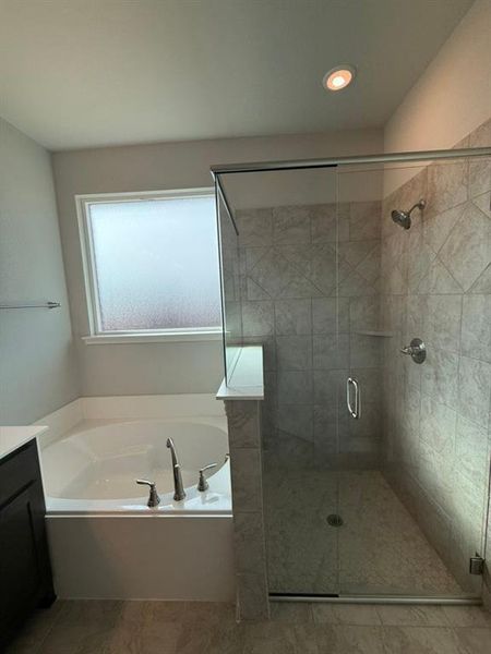 Bathroom with a garden tub, vanity, and a stall shower Bathroom with a garden tub, vanity, and a stall shower