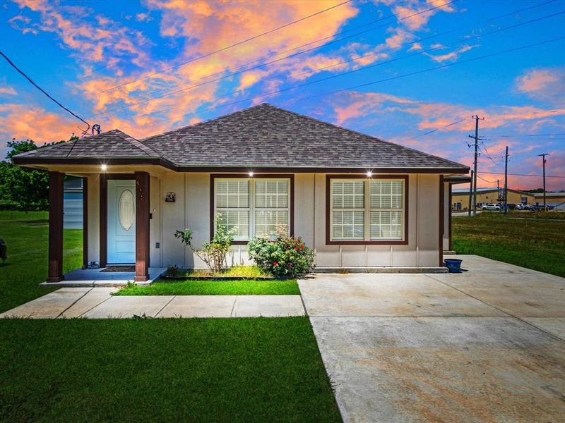 Single-story residence featuring a covered front porch with dark columns, light siding, and a shingled roof