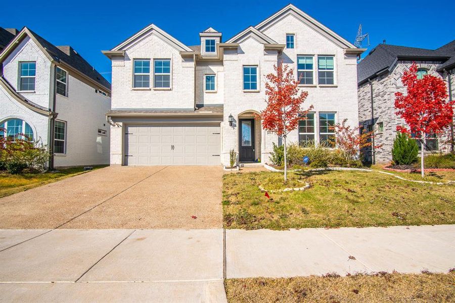 View of front of home with a front lawn and a garage