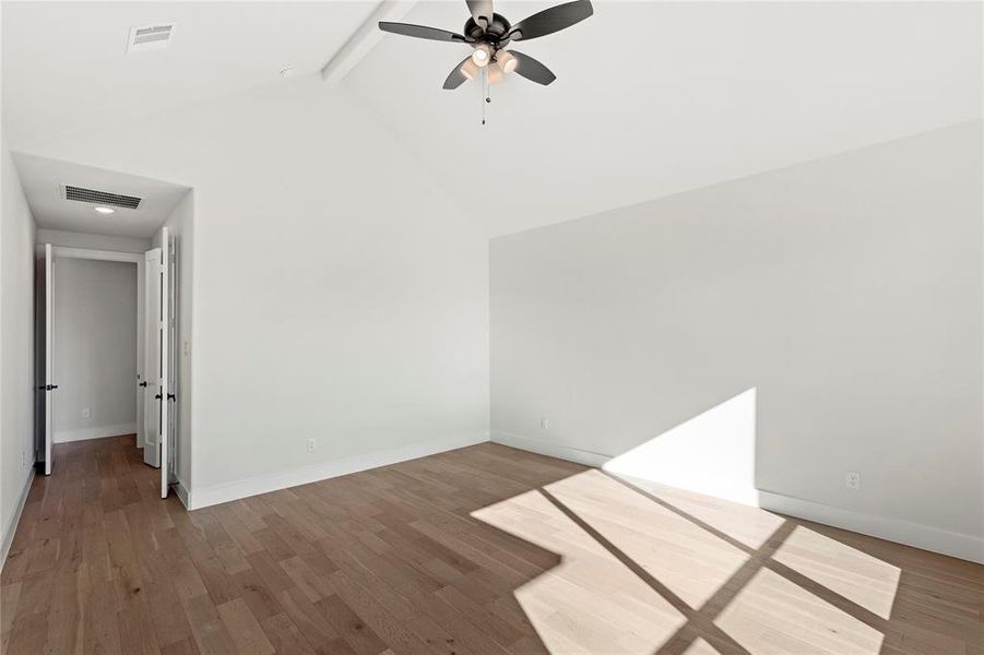 Spare room with ceiling fan, wood-type flooring, beam ceiling, and high vaulted ceiling