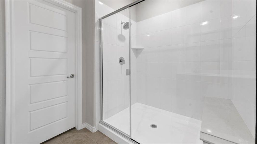 Bathroom with a stall shower and light tile patterned floors Bathroom with a stall shower and light tile patterned floors