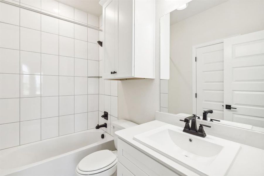 Full bathroom with vanity, toilet, and tiled shower / bath combo