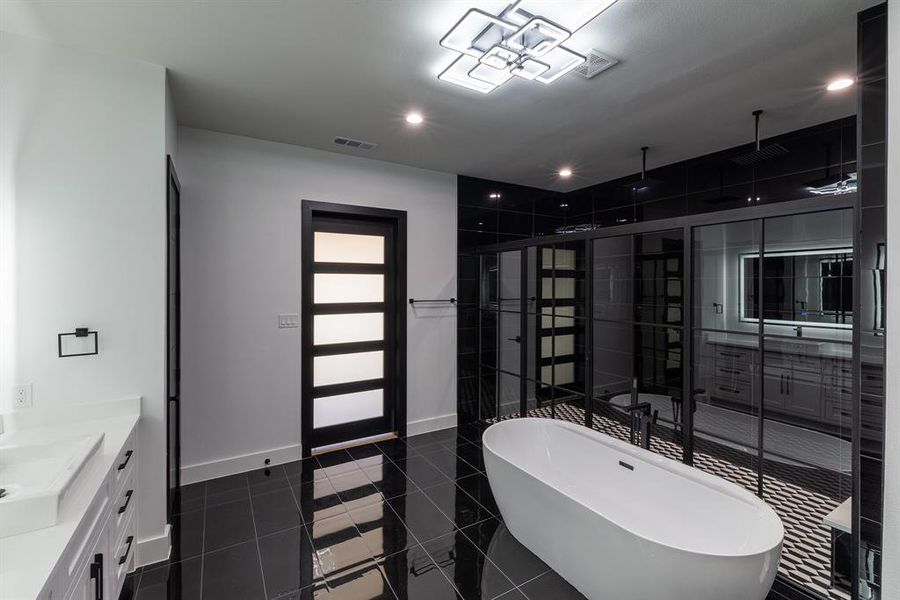 Bathroom featuring vanity, tile patterned flooring, and a washtub