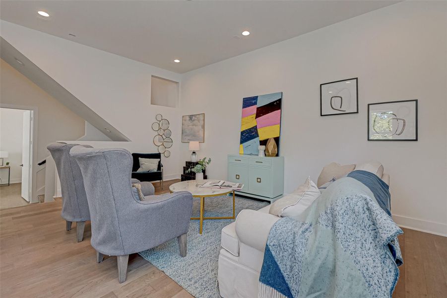 The second-floor living area invites you to unwind with stylish seating, designer touches, and a fresh color palette. A soft blend of modern comfort and vibrant personality anchors the space.