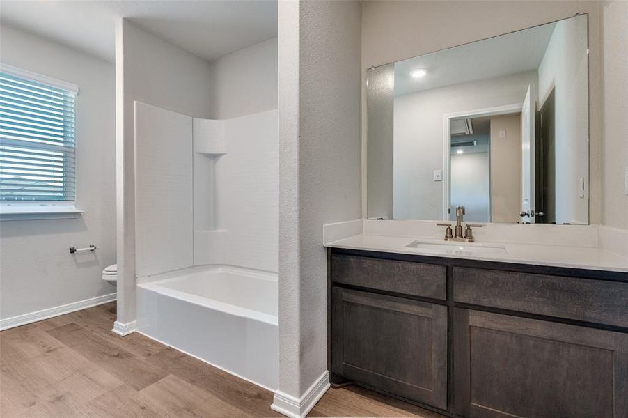 Bathroom featuring vanity, light wood-style flooring, and shower / bath combination