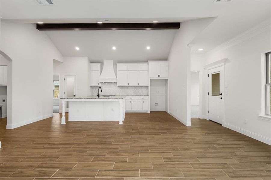 Kitchen also has small nook area for a pub table. Beautiful wood beam lines the tall ceilings in this space!